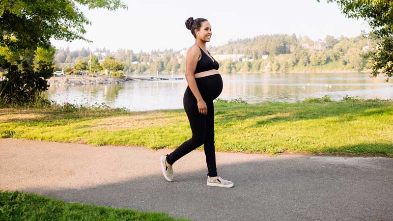 mulher grávida a caminhar